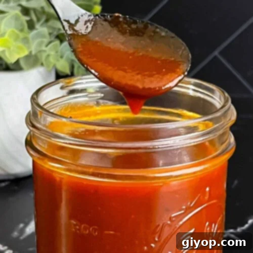 Legendary Kansas City Barbecue Sauce 10 A small bottle of Kansas City style barbecue sauce with a fresh green garnish.