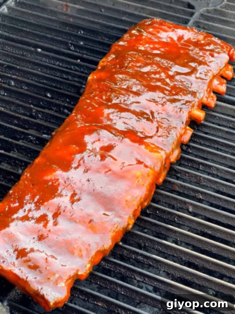 Sauced Kansas City style ribs on the smoker, caramelizing to perfection.