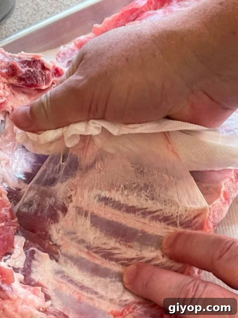 Removing the membrane from the back of a rack of ribs to ensure tender results.