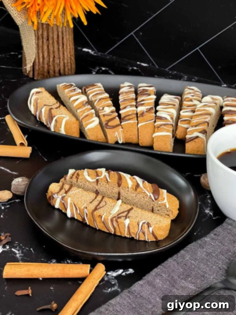 Chai biscotti presented on a dark plate alongside a warm cup of coffee.