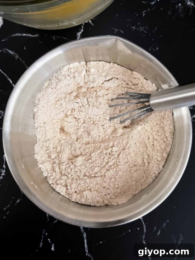 Dry ingredients being mixed in a stainless steel bowl for chai biscotti.