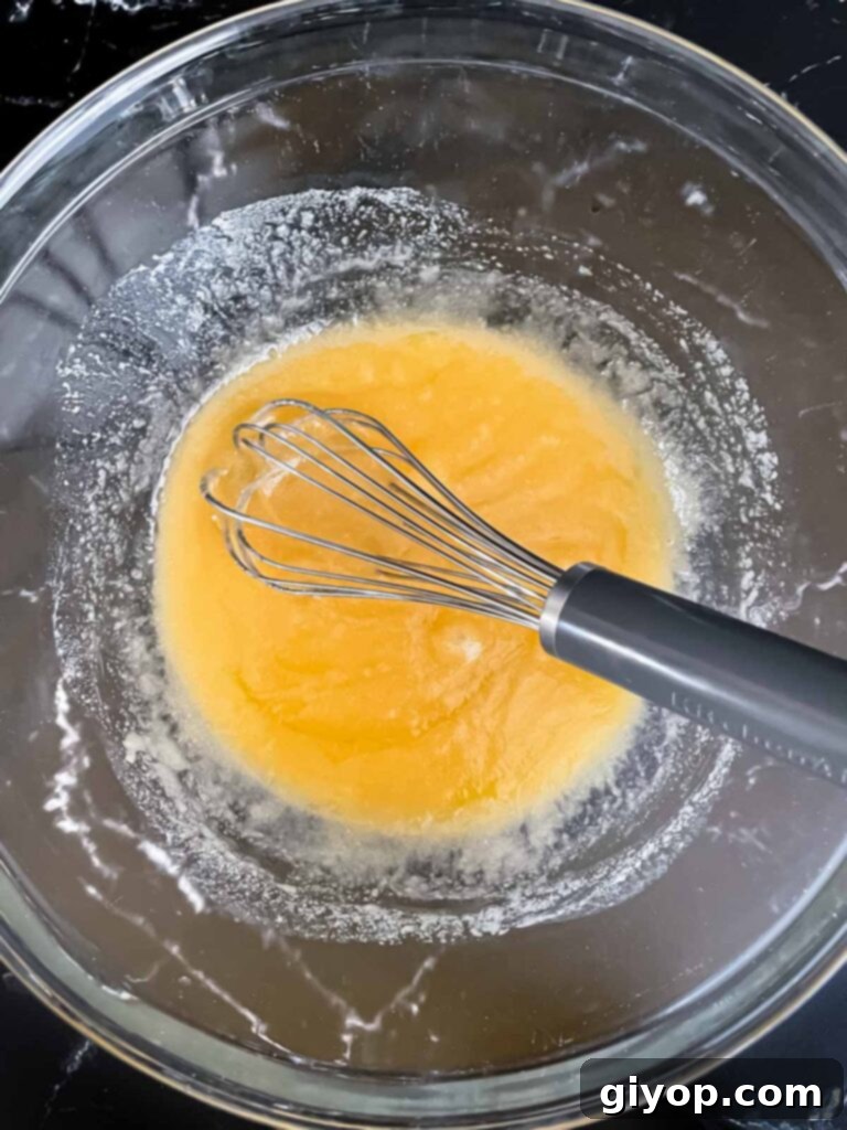 A butter and sugar mixture being prepared in a glass bowl for biscotti.