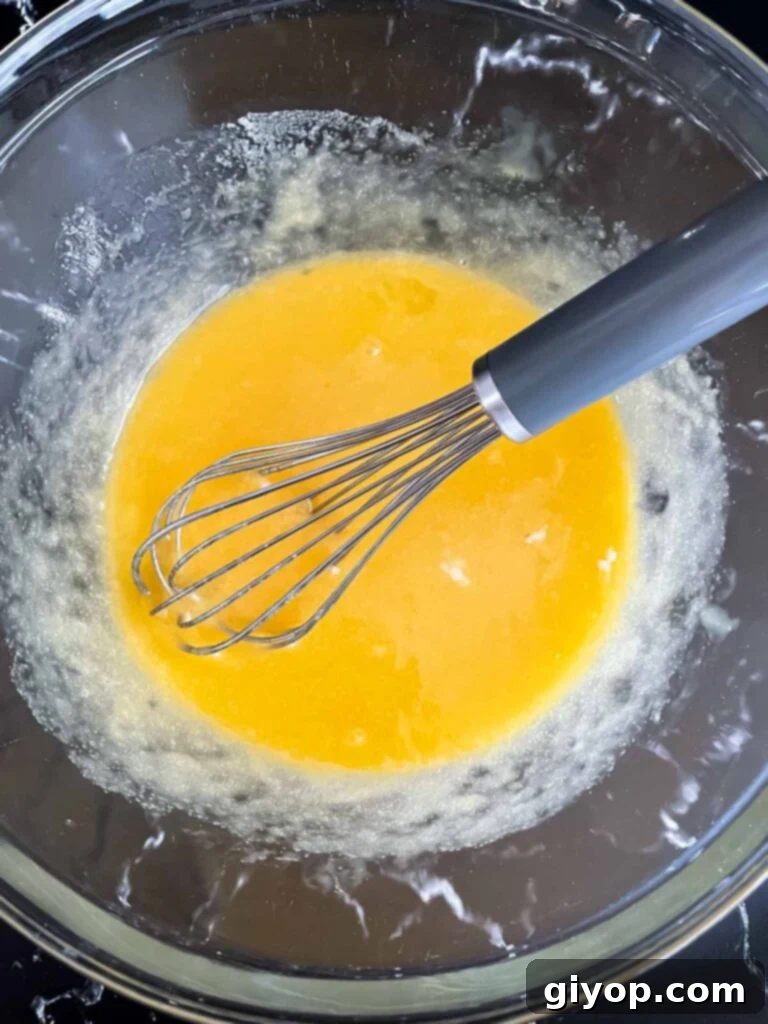 Egg, butter, and sugar mixture, smoothly combined in a glass bowl.