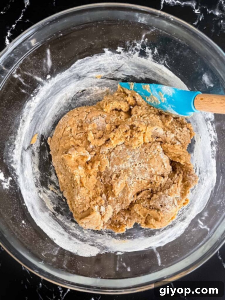 Chai biscotti dough in a glass bowl, ready for shaping.