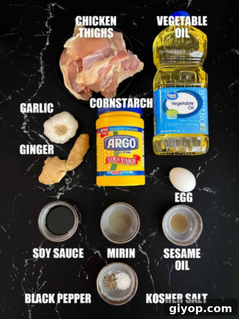 A bowl filled with bite-sized chicken pieces, ready for marination, with various spices layered on top.