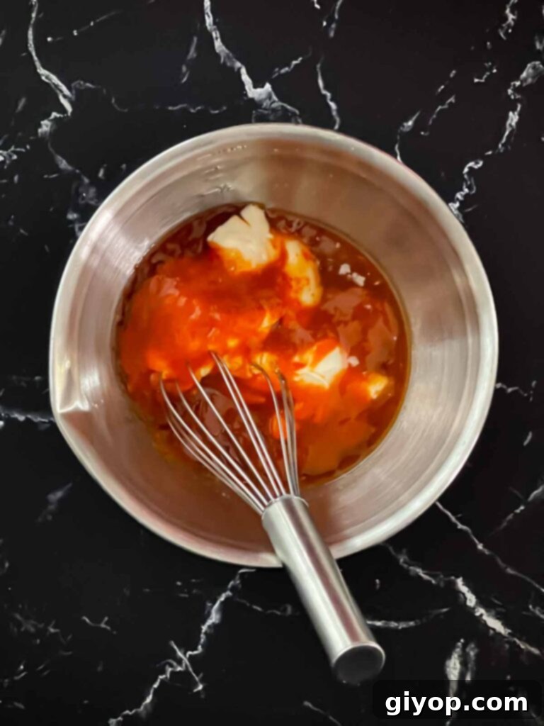 The individual ingredients for Bang Bang Sauce—Miracle Whip, Thai sweet chili, sriracha, and lemon juice—arranged in a bowl before mixing.