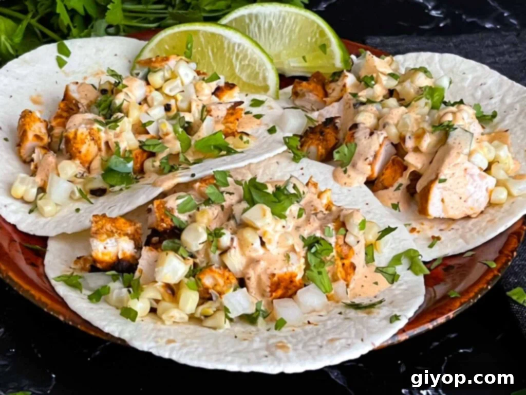 Delicious grilled chicken tacos garnished with cilantro and a generous drizzle of creamy southwest sauce.