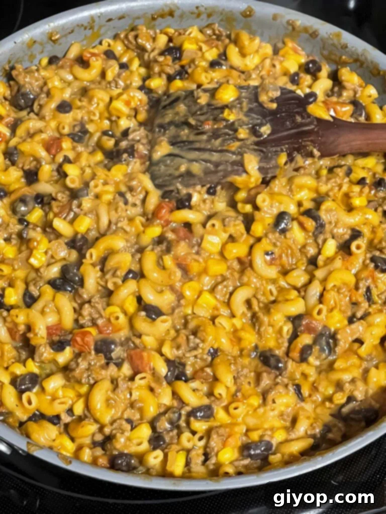 The finished taco pasta skillet, creamy and cheesy, resting on the stovetop after cooking.
