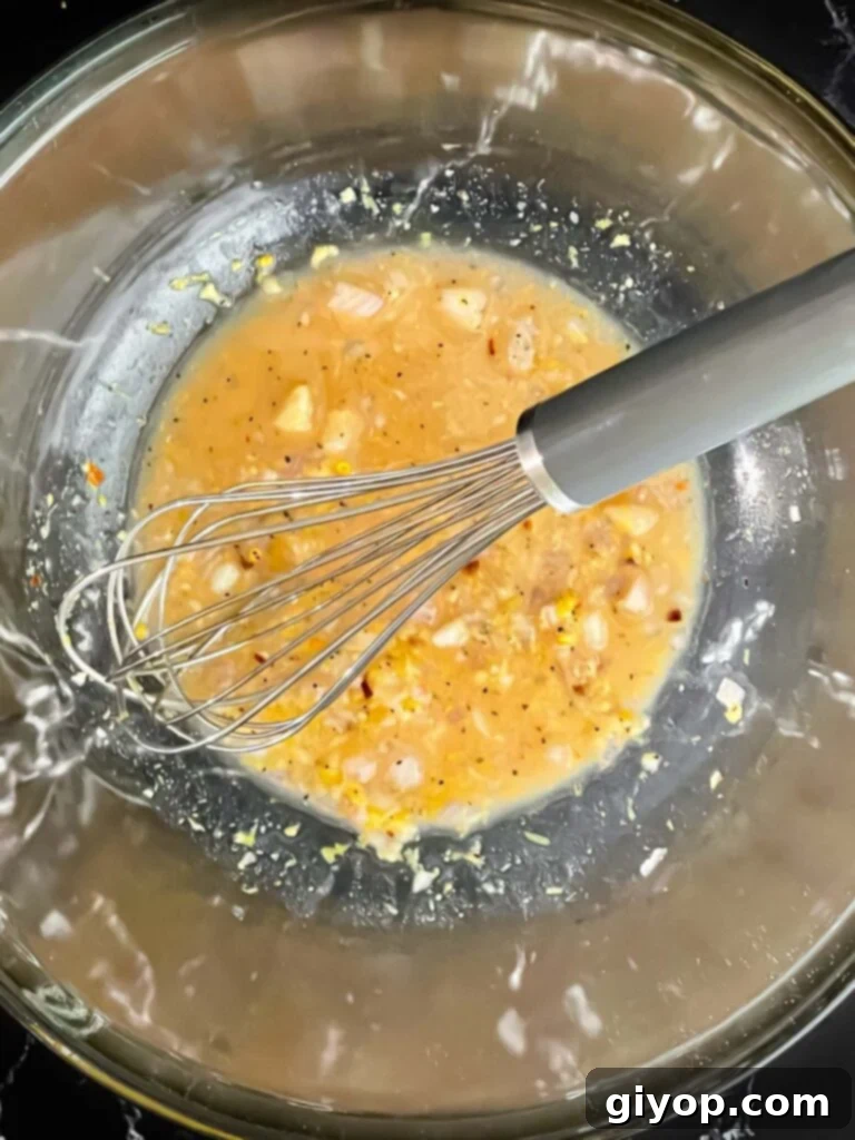 Bright Lemon White Bean Salad 4 Ingredients for a lemon dressing in a clear glass bowl, showcasing the fresh components before mixing.