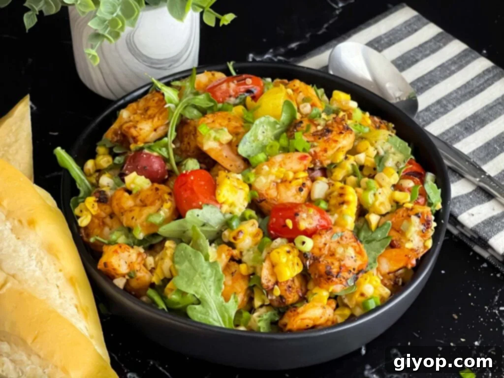 Vibrant grilled shrimp and corn salad served in a dark ceramic bowl, showcasing the colorful ingredients.