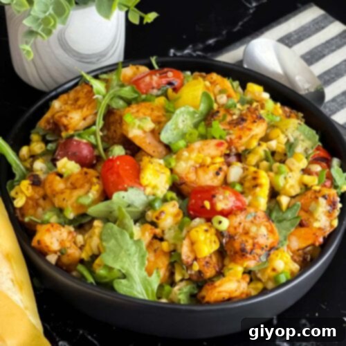 Shrimp and corn salad in a dark bowl.