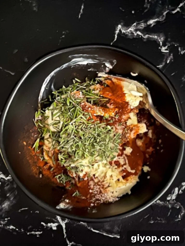 Compound butter ingredients in a dark bowl on a dark surface.