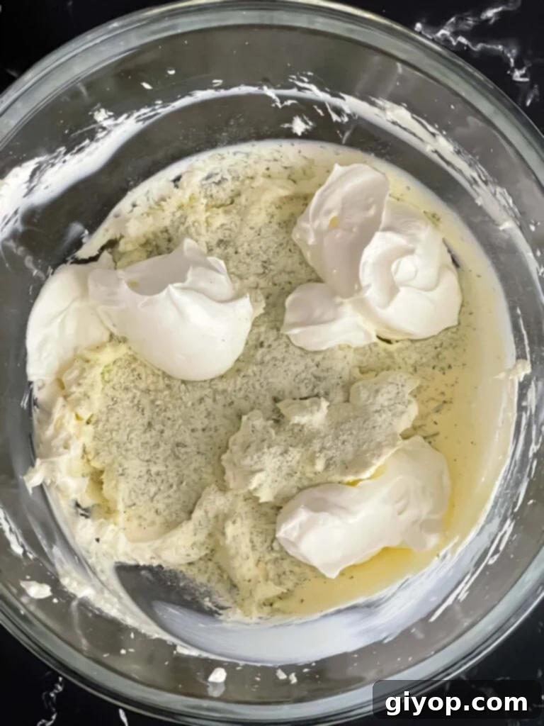 Sour cream and dry ranch seasoning mix added to the smooth cream cheese for the veggie roll ups recipe, creating the flavorful base.