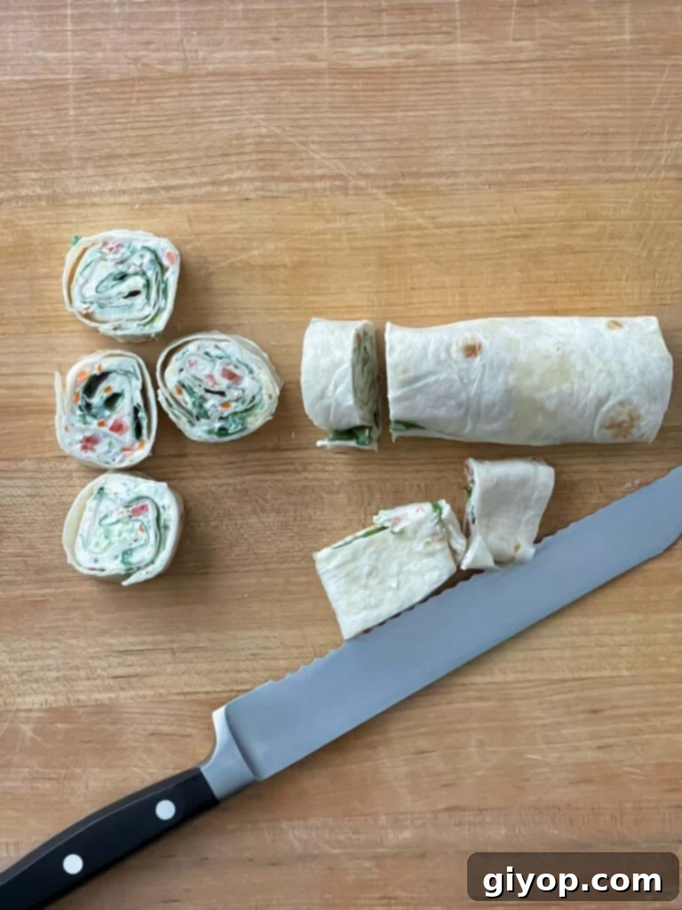 Perfectly sliced veggie tortilla roll ups displayed on a wooden cutting board, showing off their colorful layers.