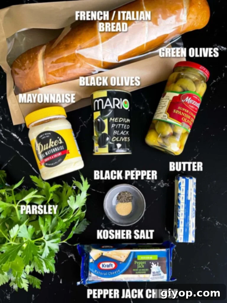 A vibrant collection of fresh ingredients for olive cheese bread, including olives, shredded cheese, and herbs, artfully arranged on a dark kitchen surface.