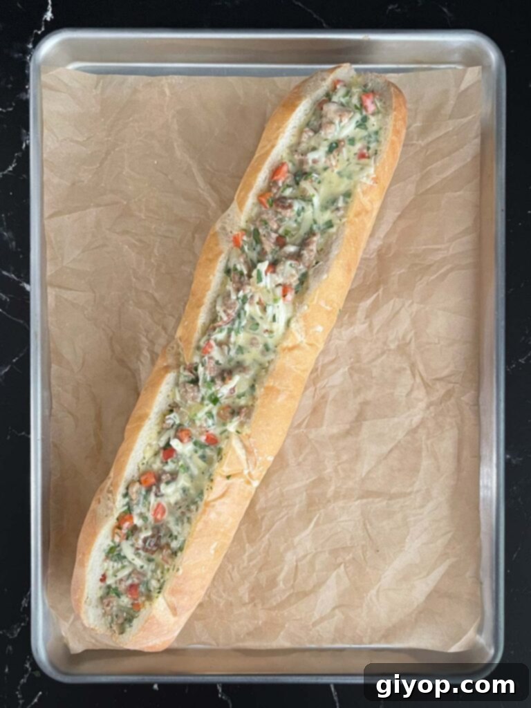 The egg and sausage mixture being spooned into a hollowed-out French bread loaf.