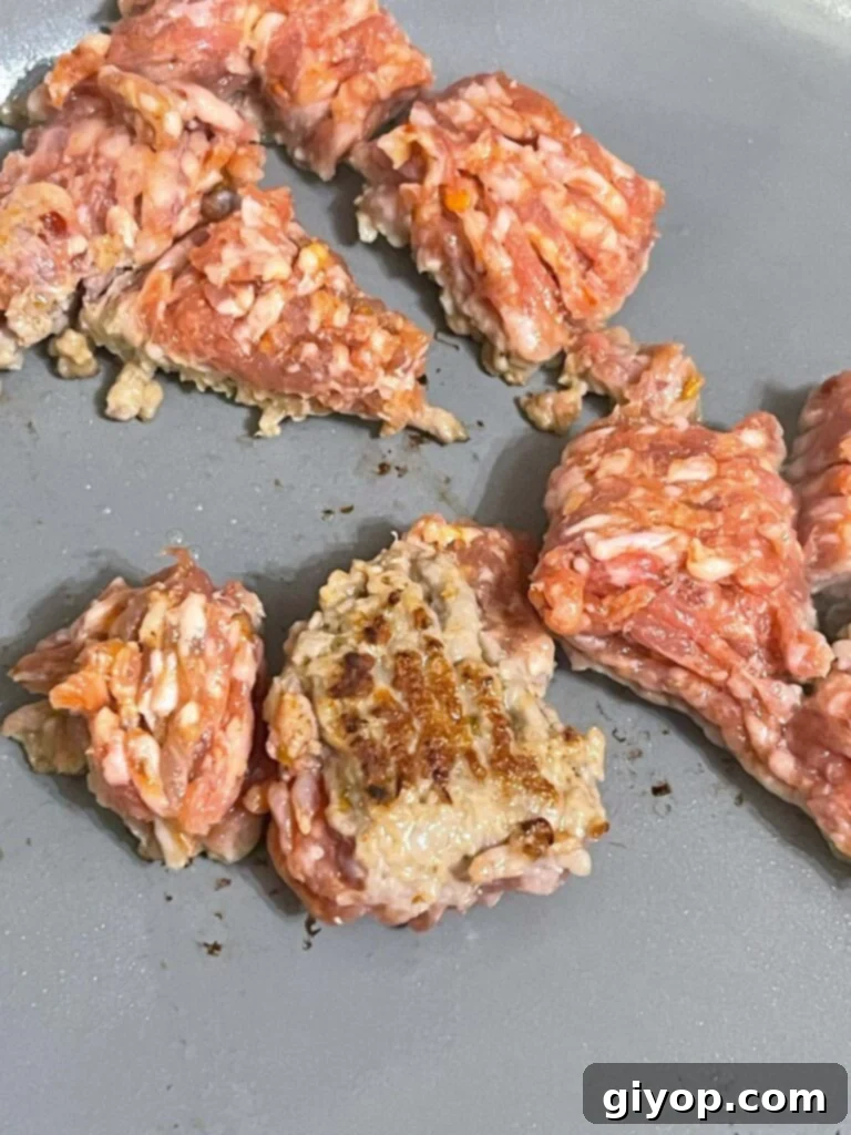 Sausage cooking in a skillet, displaying a rich brown color after browning.