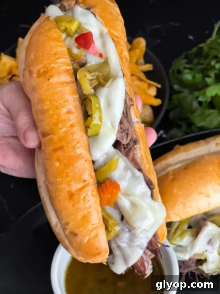 A freshly prepared Italian beef sandwich, served with a side of au jus in a small ramekin.