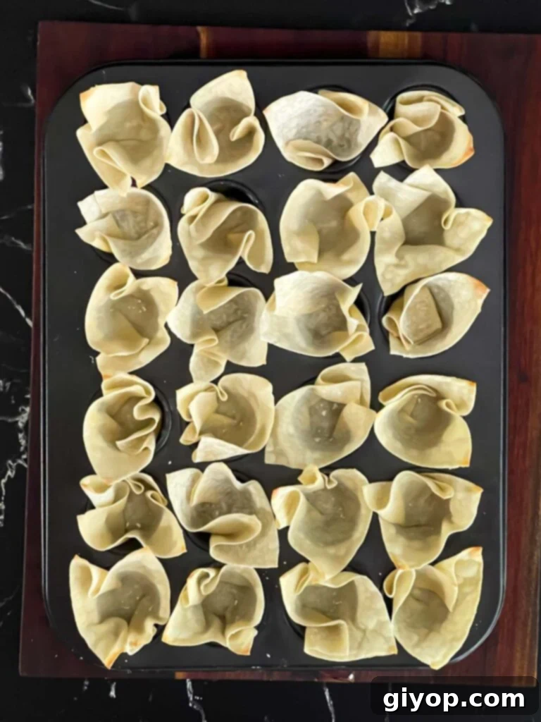 Wonton wrappers after being baked for five minutes, now lightly golden and firm.