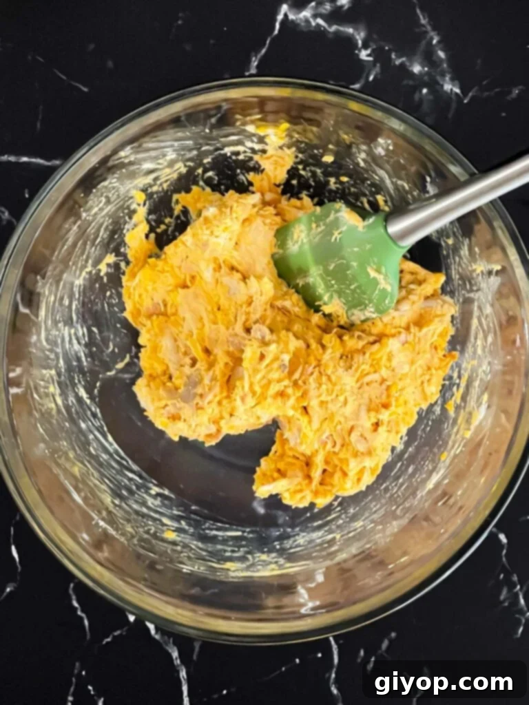 The buffalo chicken mixture perfectly combined in a mixing bowl, ready for filling.