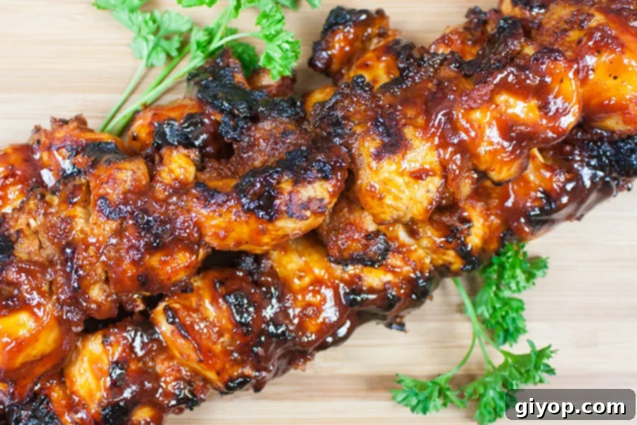 Smoky Bacon Glazed Chicken Kebabs 8 Finished Bacon Paste BBQ Chicken Kebabs arranged on a rustic wooden cutting board.