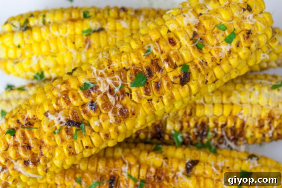 Grilled Parmesan Corn On The Cob stacked on top of each other.