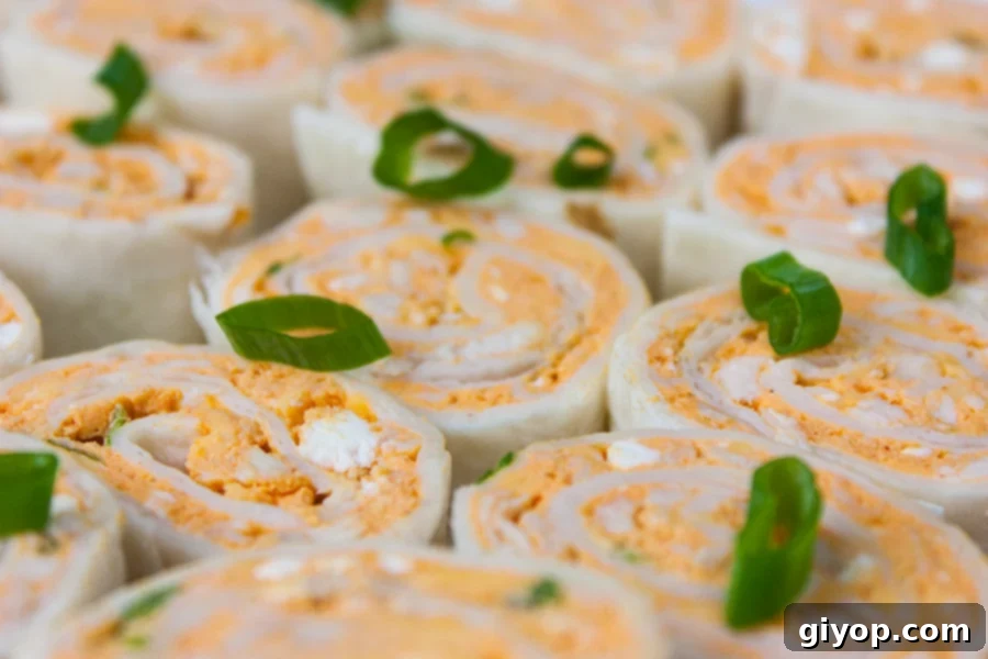 A close-up shot showcasing the delicious layers and vibrant colors of a Buffalo Chicken Pinwheel, highlighting the creamy filling and tender chicken.