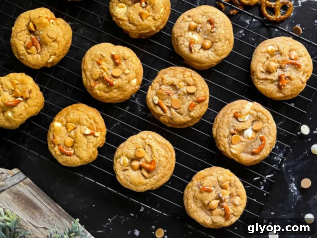 Salted Butterscotch Pretzel Cookies on a cooling rack on a dark surface.