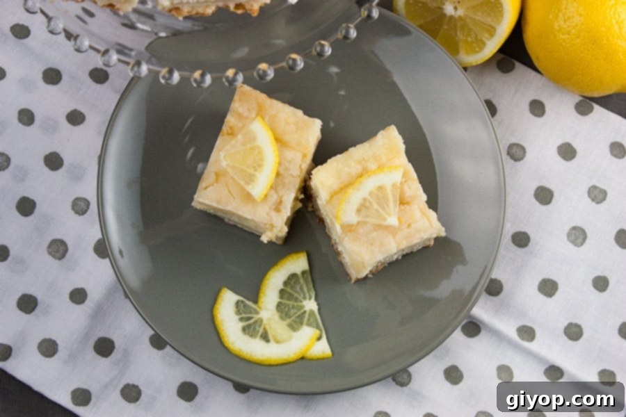 Lemony Shortbread Cheesecake Bars 4 Lemon Cheesecake Shortbread Bars on a gray plate garnished with fresh lemon slices, highlighting the creamy texture.