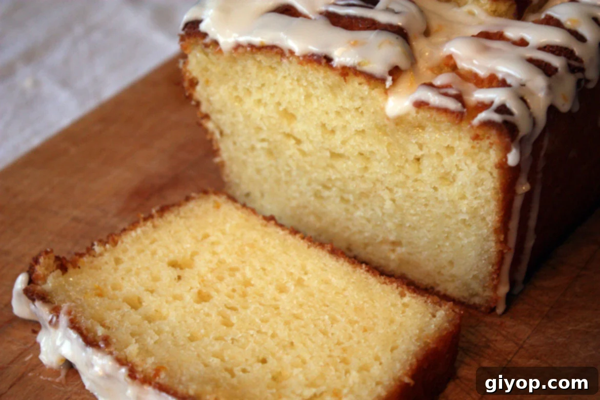 Meyer Lemon Loaf with a slice cut on a wooden cutting board.