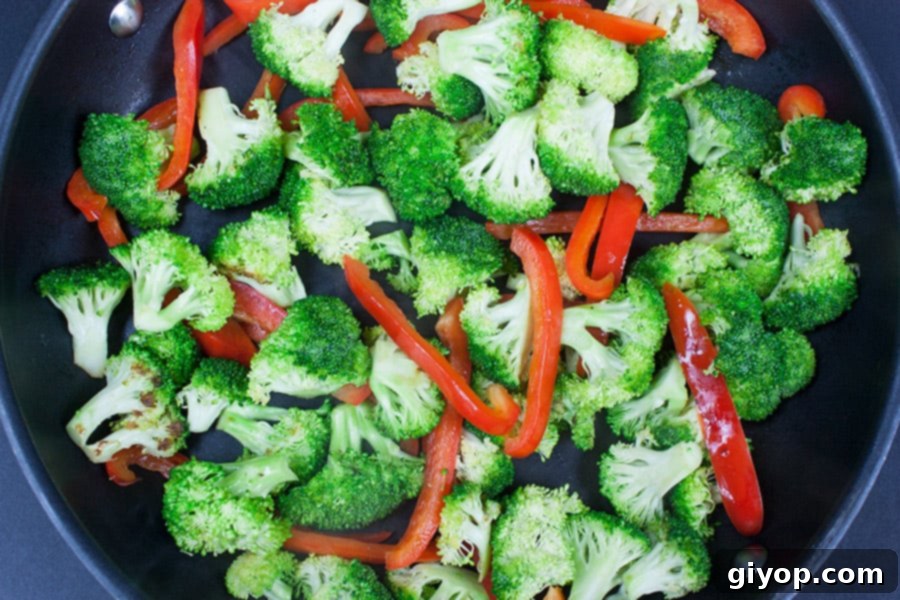 Weeknight Chicken and Broccoli Express 3 Easy Chicken and Broccoli Stir Fry - broccoli and red bell peppers being stir-fried in a skillet pan
