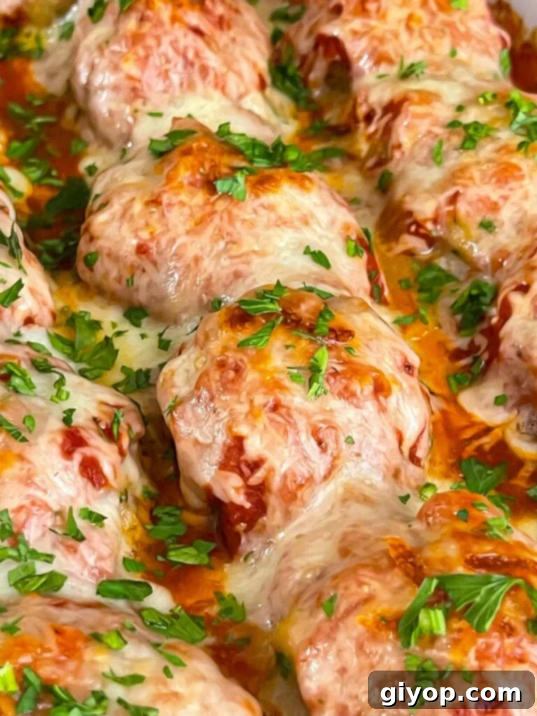 Easy baked parmesan meatballs garnished with chopped Italian flat leaf parsley.