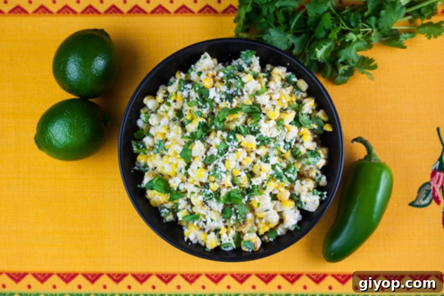 Grilled Mexican Street Corn Salad in a black bowl on a yellow back ground