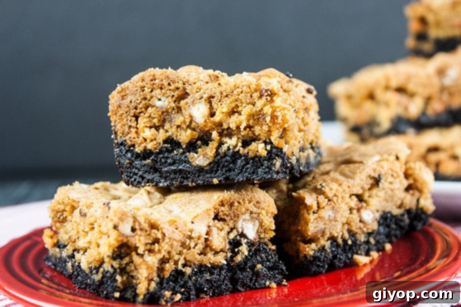 Stacked Salted Butterscotch Pretzel Brookies on a vibrant red plate, showcasing their distinct layers.