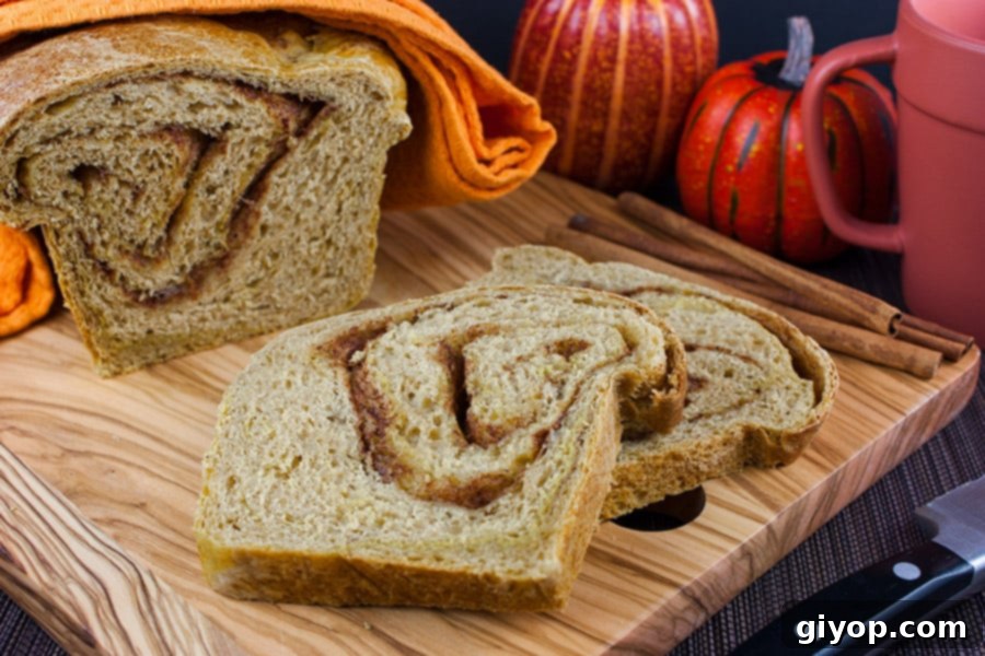 Freshly sliced Pumpkin Cinnamon Swirl Bread laid out on a rustic wooden cutting board, ready for enjoyment.