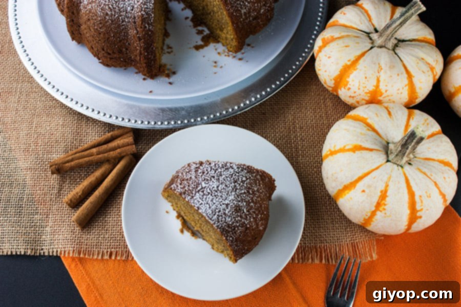 Overhead shot of a slice of the pumpkin spice bundt cake on a white plate with a fork.